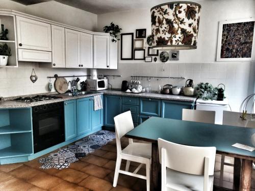 una cucina con armadi blu, tavolo e sedie di RaMaya casa d'artista 2 a Biella