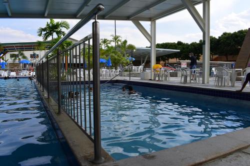 a pool at a resort with a dog in the water at diRoma Fiori - Apartamentos JN in Caldas Novas