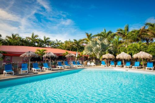 a pool at the resort with chairs and umbrellas at EAST KEYS - East Cottages in Le Vauclin