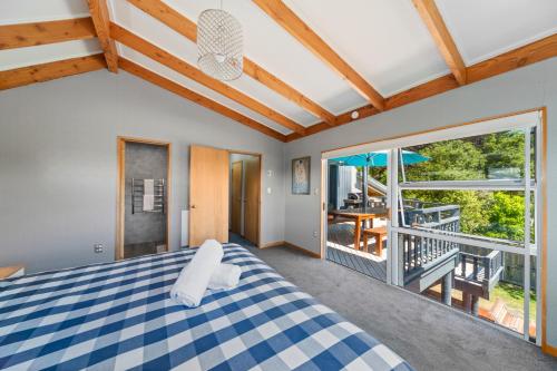 ein Schlafzimmer mit einem Bett und einem Balkon in der Unterkunft Choice Wharewaka - Taupo Holiday Home in Taupo
