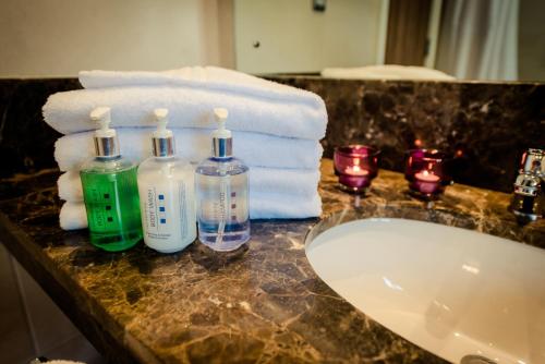 a bathroom counter with a sink and towels at Glashaus Hotel in Tallaght