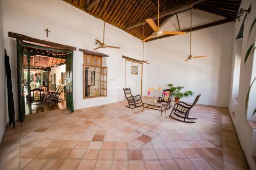 sala de estar con sillas, mesa y ventiladores de techo en Hotel San Andres Mompox, en Mompox