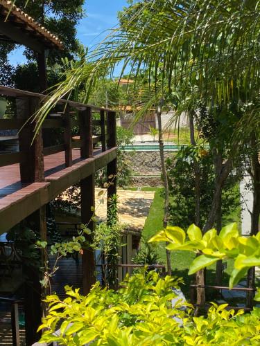 une passerelle en bois dans un jardin avec des plantes vertes dans l'établissement Recanto da Ferradura, à Búzios