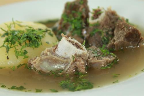 a plate of food with meat and vegetables on a plate at Hospedaje y Zona de Camping Pistacho in Villa de Leyva