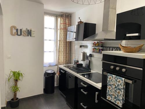 - une cuisine équipée d'un four avec plaques de cuisson en noir et blanc dans l'établissement Appartement F3 hyper centre, à Ajaccio