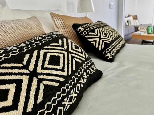 two black and white pillows on a bed at Casa Rural Albireo, rebosante de luz y naturaleza in Sanlúcar de Guadiana
