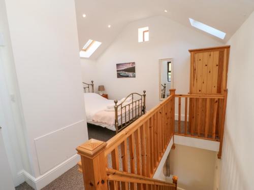 uma escada que leva a um quarto com uma cama em Drover's Cottage em Wolsingham