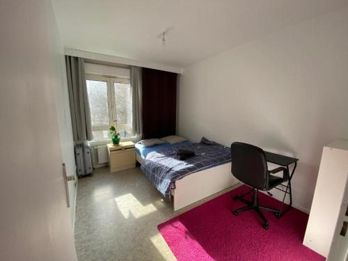 ein Schlafzimmer mit einem Bett, einem Stuhl und einem Fenster in der Unterkunft Nancy hyper centre, chambre privé chez l'habitant en colocation in Nancy