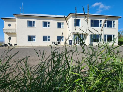 a white building in front of a building at Hlín Guesthouse in Varmahlid