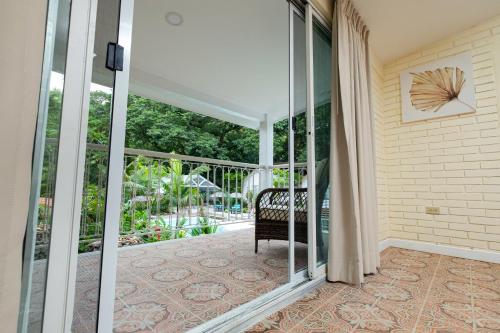 an open glass door to a patio with a chair at Angeli Gardens Boutique Hotel in San Pedro Sula