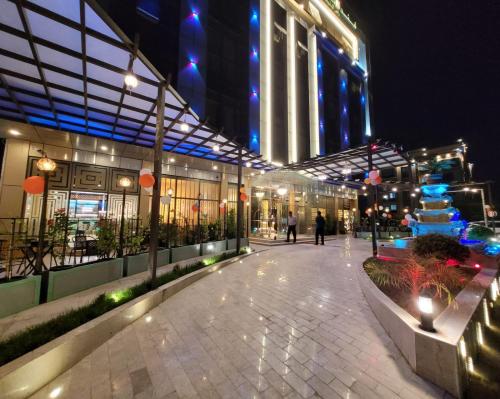 un bâtiment avec une passerelle devant lui la nuit dans l'établissement Camphor Hotel, à Ras al Khaimah
