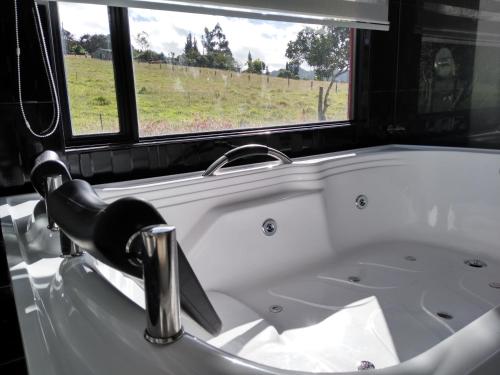a bath tub with a sink and a window at Sierra Morena in Cogua