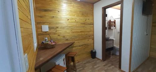uma casa de banho com uma parede de madeira e um balcão de madeira em Recanto do Araçá em Urubici