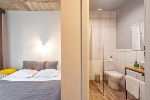 sypialnia z łóżkiem oraz łazienka z toaletą w obiekcie Like Home on IN w Iwano-Frankiwsku