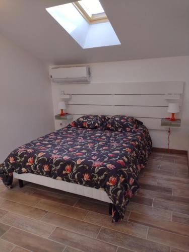 een slaapkamer met een bed in een kamer met een dakraam bij LES GITES DU LAUZON in Montségur-sur-Lauzon