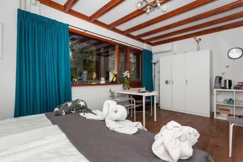 a bedroom with towels on a bed with a table at Maupertuus Bennekom in Bennekom