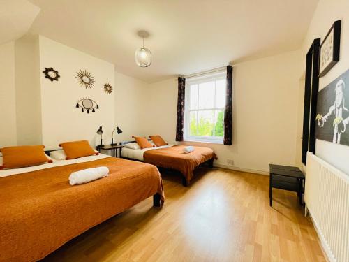 a bedroom with two beds and a window at Fishponds Lodge in Bristol