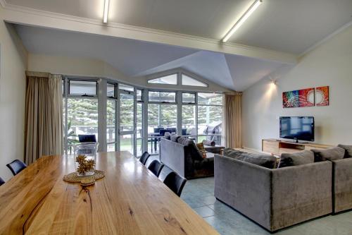 a living room with a wooden table and a couch at Port Lincoln Foreshore Apartments in Port Lincoln