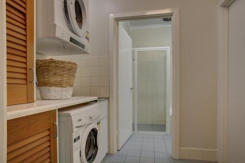 a kitchen with a washing machine and a washer and dryer at Port Lincoln Foreshore Apartments in Port Lincoln