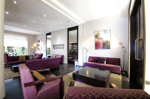 - un salon avec des canapés et des chaises violets dans l'établissement Best Western Plus Hotel Plaisance, à Villefranche-sur-Saône