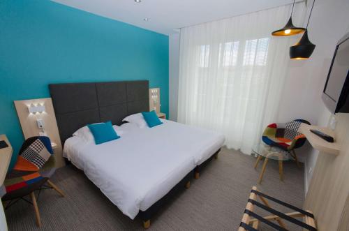 a bedroom with a large bed and a blue wall at Best Western Plus Hotel Plaisance in Villefranche-sur-Saône