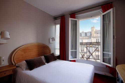 una camera con un letto e una grande finestra di Best Western Aramis Saint Germain a Parigi