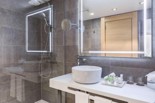 a bathroom with a sink and a shower at NH Collection Brussels Grand Sablon in Brussels