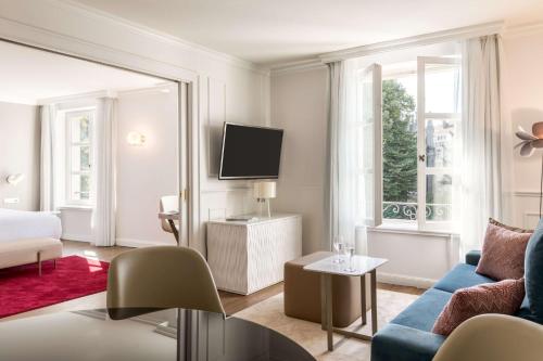 a living room filled with furniture and a tv at NH Collection Brussels Grand Sablon in Brussels