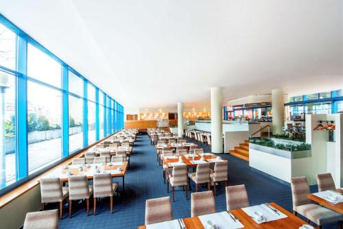 布拉格的住宿－布拉格市NH酒店，用餐室设有桌椅和窗户。