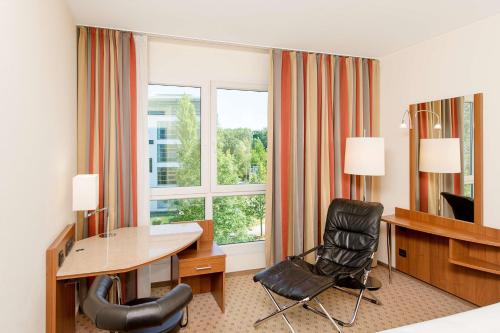 a hotel room with a desk and a window at NH München Ost Conference Center in Munich