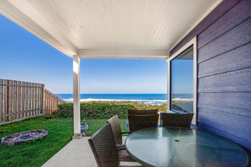 a patio with a table and chairs and the ocean at Coastal Serenity in Lincoln City