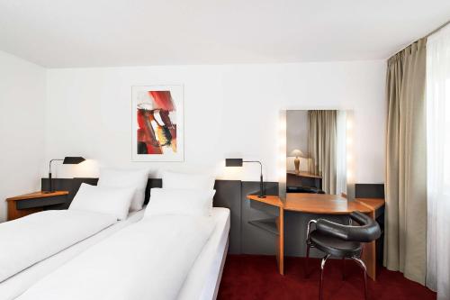 ein Hotelzimmer mit 2 Betten und einem Schreibtisch in der Unterkunft NH Hirschberg Heidelberg in Hirschberg an der Bergstraße