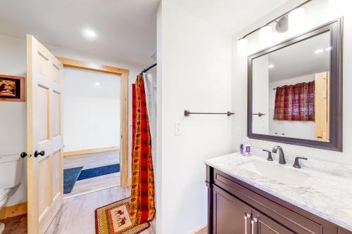 W łazience znajduje się umywalka i lustro. w obiekcie The Grouse House w mieście Greenville