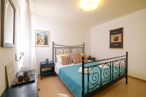 - une chambre avec un lit noir et une couette bleue dans l'établissement Stella Di Mare holiday house, à Agios Ioannis