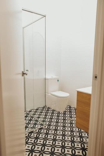 a bathroom with a toilet and a glass shower at Mill St. Retreat in Clare