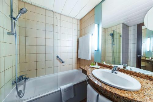 布達佩斯的住宿－NH布達佩斯市酒店，一间带水槽、浴缸和淋浴的浴室