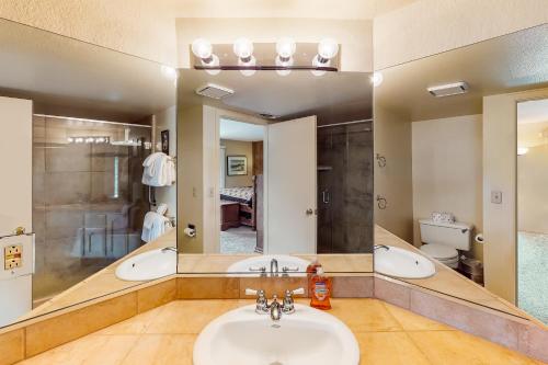 La salle de bains est pourvue de 2 lavabos et d'un grand miroir. dans l'établissement Eagle's Nest #87, à Lakeshore