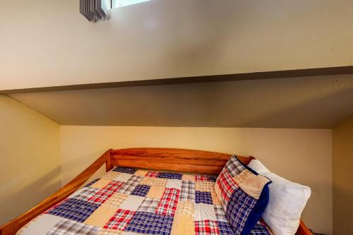a bed with a quilt and two pillows on it at Eagle's Nest #87 in Lakeshore