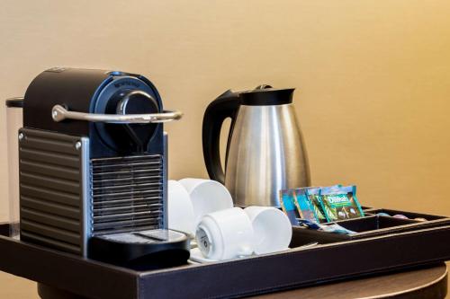 a black tray with a coffee maker and dishes at NH Centre Utrecht Hotel in Utrecht