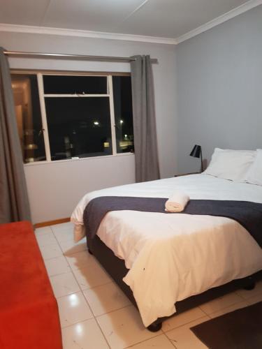 a bedroom with a large bed and a window at Menlyn Place in Pretoria