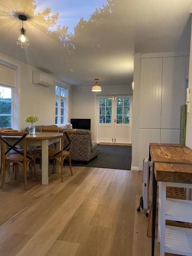 a living room with a table and a couch at Ohariu Farm Cottage in Johnsonville