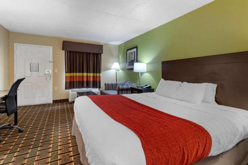 a hotel room with a large bed with a red blanket at SureStay Hotel by Best Western Lenoir City in Lenoir City