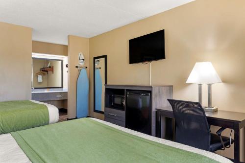 a hotel room with a bed and a desk with a television at SureStay Hotel by Best Western Lenoir City in Lenoir City