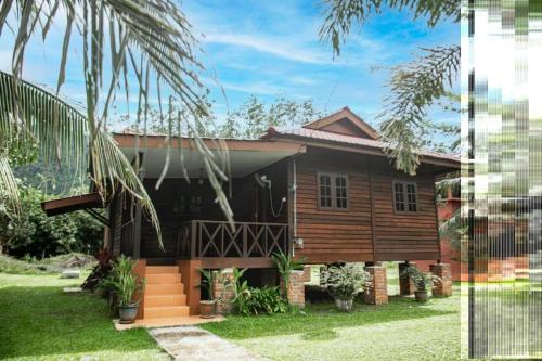 a home with a wooden house with a yard at Padimas Villa @Datai Valley in Teluk Datai