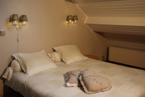 Una cama con dos almohadas y una manta. en B&B Huize Bex en Overpelt