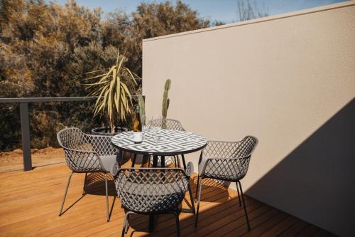 Un patio con una mesa y sillas en una terraza. en Mill St. Retreat, en Clare
