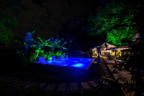 a swimming pool at night with green lights at Angeli Gardens Boutique Hotel in San Pedro Sula