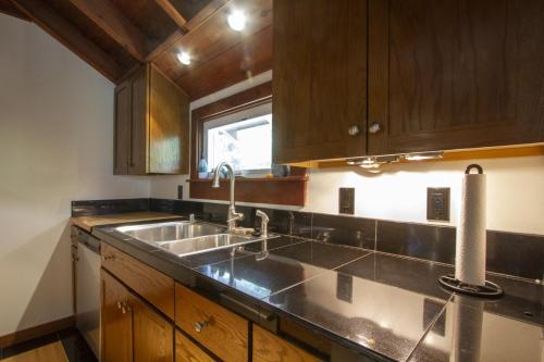 una cucina con un lavandino e una finestra di Villa Mimosa Hot Tub Fire Table BBQ Walk to River Dog Friendly a Guerneville