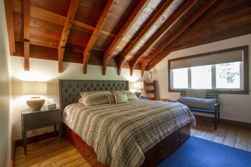 una camera da letto con un letto e una grande finestra di Villa Mimosa Hot Tub Fire Table BBQ Walk to River Dog Friendly a Guerneville