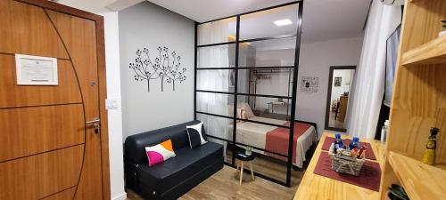 a room with a bedroom with a bed and a chair at Apezinho.Loft in Rio de Janeiro
